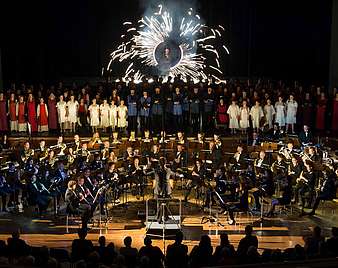 Chor und Orchester bei Carmina Burana auf der Bühne mit Feuerwerk im Hintergrund