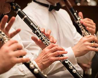 Hände von Musikern, die Klarinette spielen.