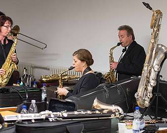 Drei Saxophonisten beim Stimmen der Instrumente