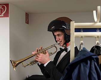 Trompeter in der Garderobe mit Sturzhelm.